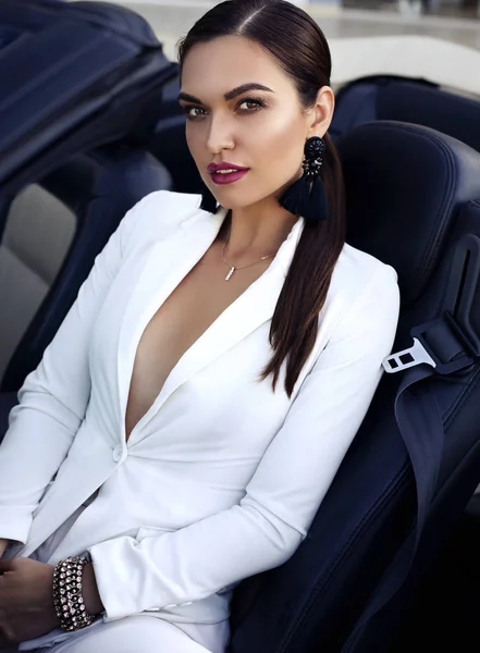 Mulher sensual com cabelo escuro posando em carro luxuoso — Fotografia de Stock