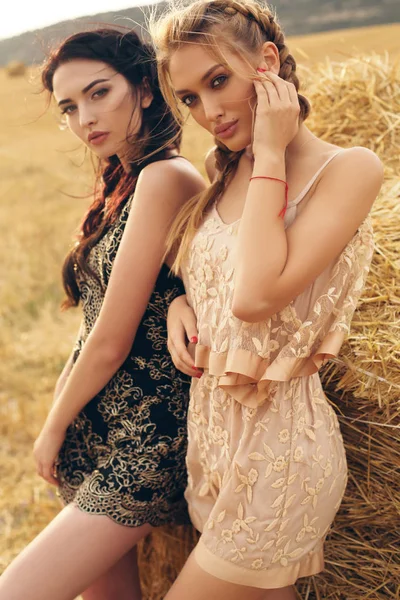 Meninas bonitas em roupas casuais posando no feno — Fotografia de Stock