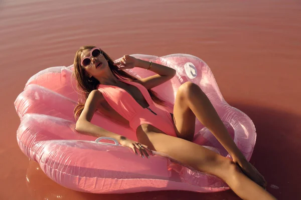 Красивая девушка с темными волосами в элегантном купальнике позирует рядом с ре — стоковое фото