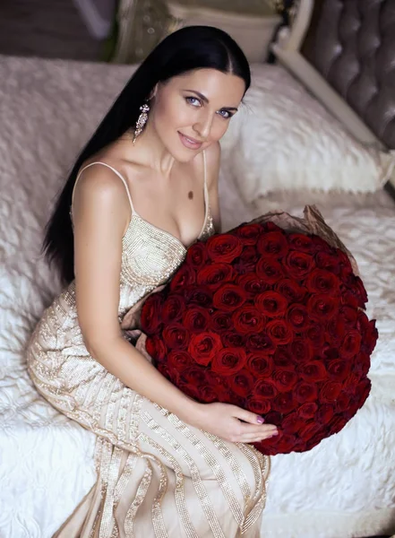 Gorgeous woman with dark hair in luxurious dress posing with big — Stock Photo, Image