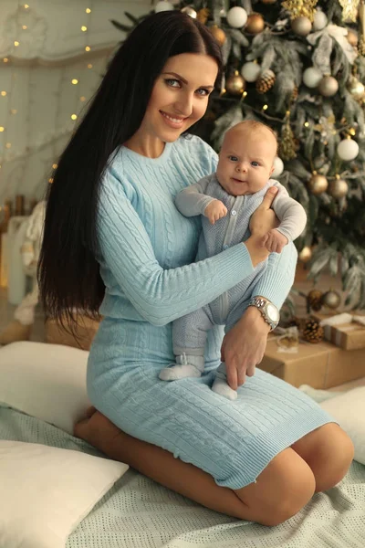 Bella donna con i capelli scuri posa vicino all'albero di Natale con h — Foto Stock