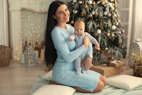 Beautiful woman with dark hair posing near Christmas tree with h — Stock Photo, Image