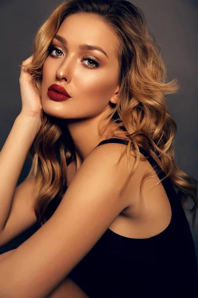 Beautiful girl with blond curly hair and evening makeup — Stock Photo, Image