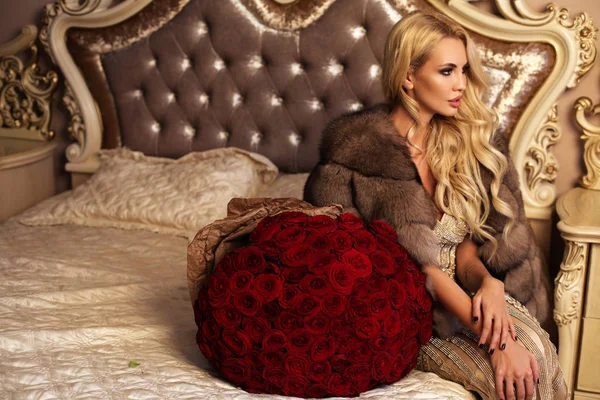 Piękna kobieta z blond włosami w luksusowe ubrania pozowanie z — Zdjęcie stockowe