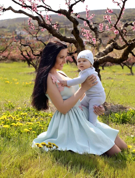 Mutter mit dunklen Haaren im eleganten Kleid posiert mit ihrem kleinen Cu — Stockfoto