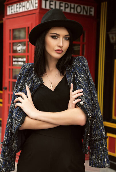 beautiful girl with dark hair in elegant clothes walking by the 