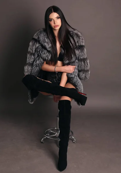 Beautiful woman with dark hair in luxurious fur coat and boots — Stock Photo, Image
