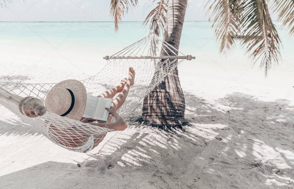 Travel series. Maldive islands. girl is relaxing in hammock and reading book