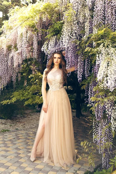 Mujer con el pelo largo en vestido de lujo posando entre la floración w —  Fotos de Stock