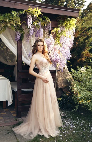 Mujer con el pelo largo en vestido de lujo posando entre la floración w —  Fotos de Stock