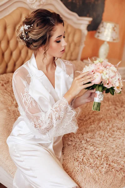 Mooie vrouw met donker haar poseren in zijden mantel in de ochtend — Stockfoto