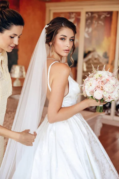 Schöne glückliche Braut in elegantem Brautkleid mit Blumenstrauß — Stockfoto