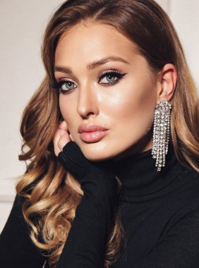 Güzel, şehvetli, sarı kıvırcık saçlı, zarif elbiseli bir kadın.