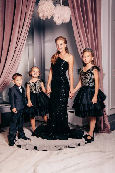 Mother with blond hair in elegant dress posing with her three ch — Stock Photo, Image