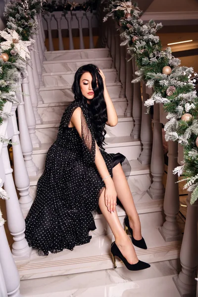 Hermosa chica con el pelo oscuro en vestido elegante posando en decora — Foto de Stock