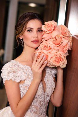 Güzel, genç, siyah saçlı, lüks gelinlikli bir gelin. 