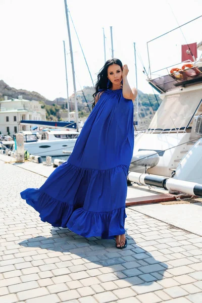 Beautiful woman with dark hair in elegant dress posing near luxu — ストック写真