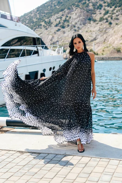 Bela mulher com cabelo escuro em vestido elegante posando perto de luxu — Fotografia de Stock