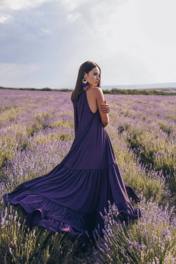 Lavanta tarlasında poz veren siyah saçlı, güzel seksi bir kadının moda fotoğrafı.