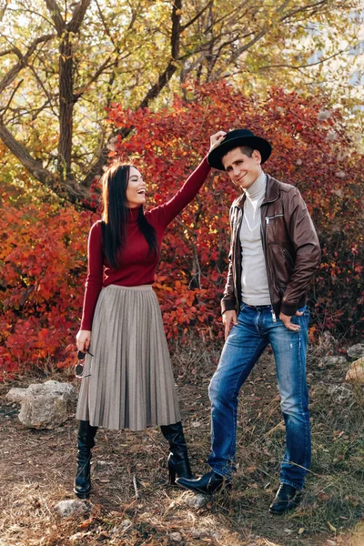 美丽的年轻夫妇穿着雅致的衣服在秋天的公园里摆姿势的户外时尚照片 — 图库照片