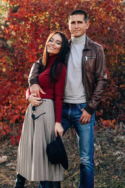 美丽的年轻夫妇穿着雅致的衣服在秋天的公园里摆姿势的户外时尚照片 — 图库照片