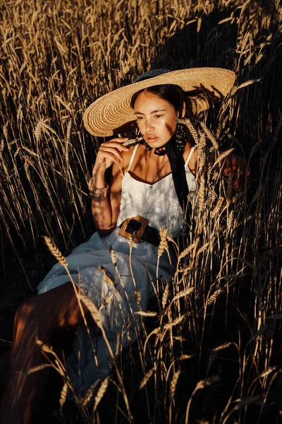 穿着雅致的衣服 头戴大草帽 一头乌黑的头发 站在麦田里的美丽女子的户外时尚照片 — 图库照片