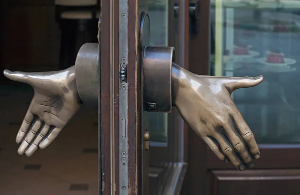 Shop door handle depicting the open hands — Stock Photo, Image