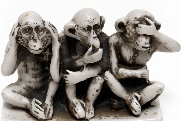 Three wise monkeys small figurine isolated. The proverbial principle \