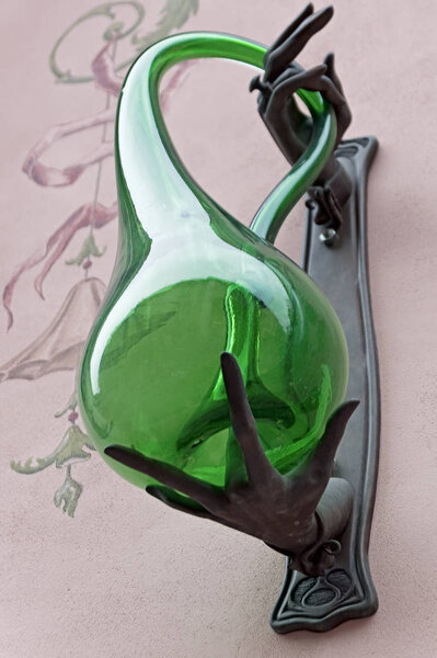 Curved bottle of green glass in odd hand decorating the unidentified house in Lviv, Ukraine