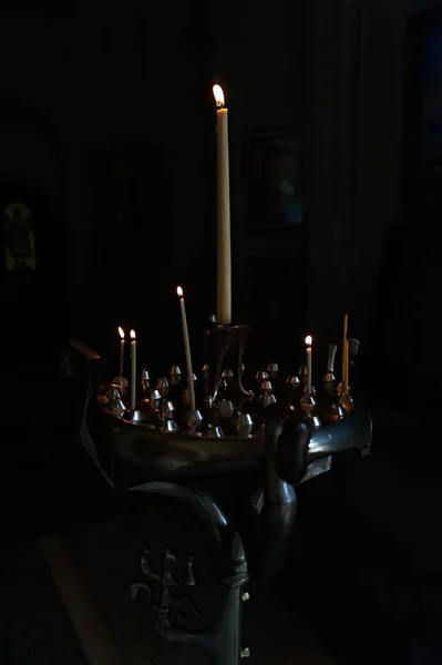 Candle stick with some burning candles in the dark empty room