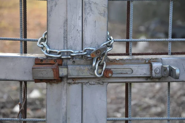锈迹斑斑的大门上的挂锁 锁链和老栓 — 图库照片