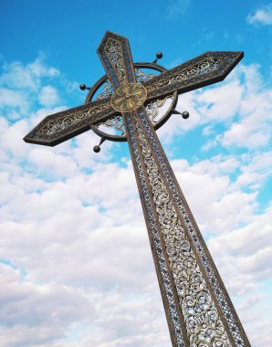 Mavi bulutlu gökyüzünün arka planında Ortodoks haçı 
