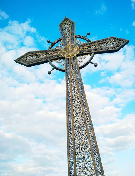 Orthodox cross against the background of the blue cloudy sky