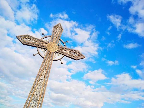 Orthodox cross against the background of the blue cloudy sky