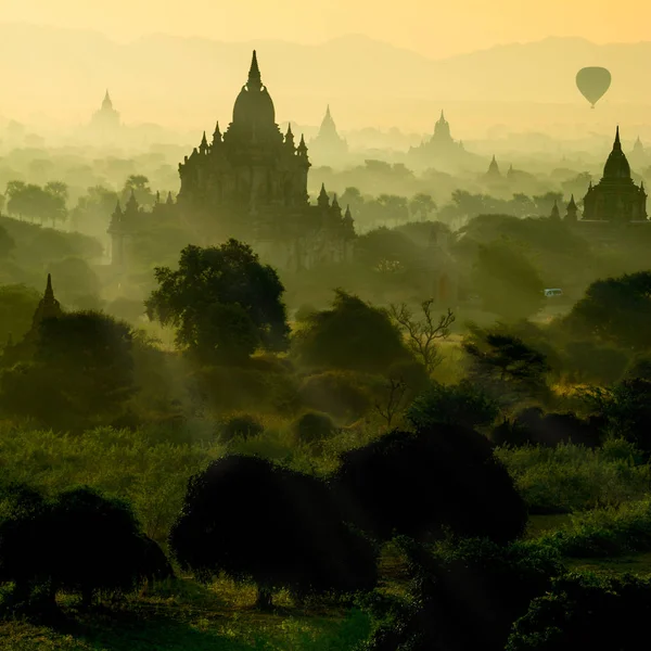 Scenic sunrise with silhouette balloons above ruin pagoda in Bagan, Myanmar. — Stock Photo, Image