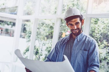 Mimar mavi baskı projesine zevkle bakıyor ve gülümsüyor.