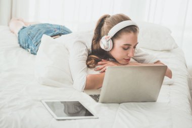 Yatak odasında laptopunun yanında uyuyan güzel kadınlar.