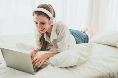 Yatak odasında bilgisayarı olan serbest çalışan kadın..