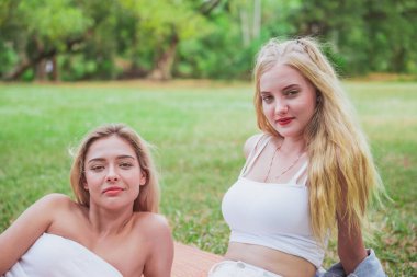 İki kadın dinlenir ve parkta kalır.