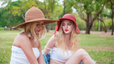 Genç ve güzel bir kadın parkta arkadaşlarıyla konuşup sohbet ediyor.