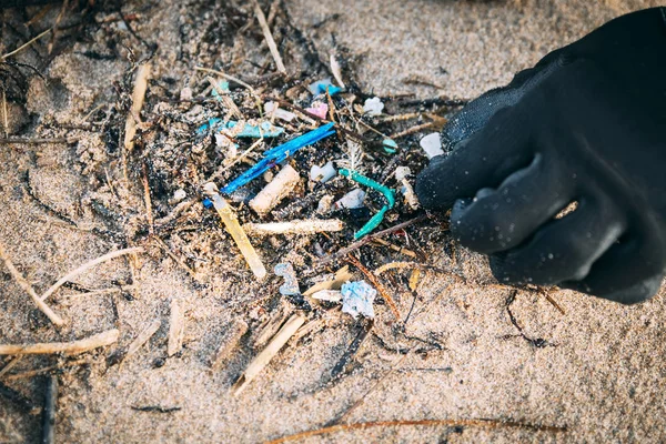 Close-up of a volunteer cleaning up microplastics in a beach. — Stock Photo, Image