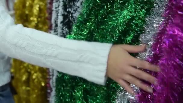 Woman touching Christmas tinsel in the store — Stock Video