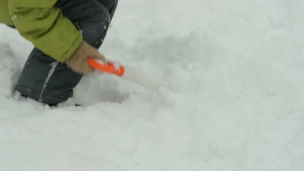 Kid rengöring snö med leksak spade — Stockvideo