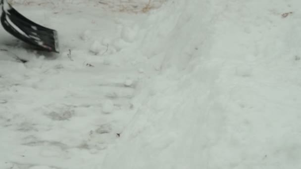 Man sneeuw in de buurt van de garage schoonmaken — Stockvideo