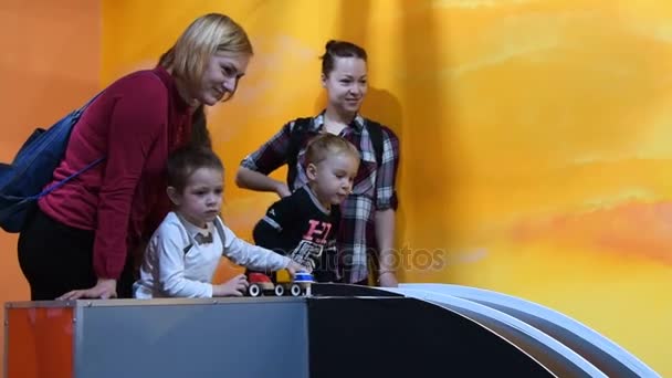 Mães e filhos no parque de diversões interior — Vídeo de Stock