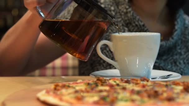 Frau wird Tee und Pizza essen — Stockvideo