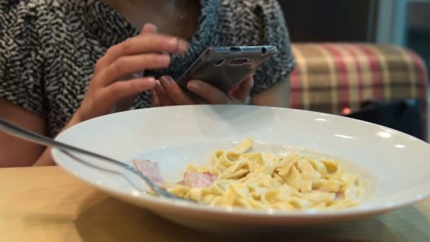 Mulher jantando e usando telefone inteligente — Vídeo de Stock