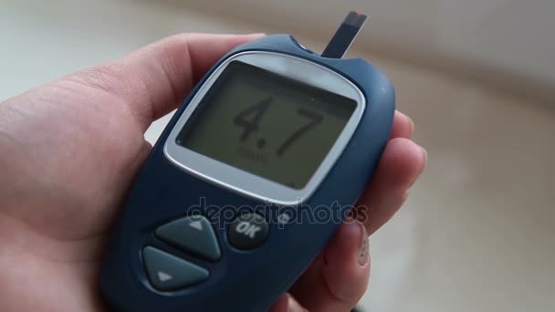 Ženská ruka s glukometr zobrazuje rozsah normálního cukru v krvi — Stock video