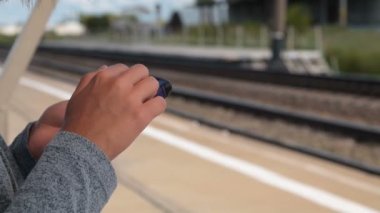 Tren bekliyorsun ve cep telefonu kullanarak