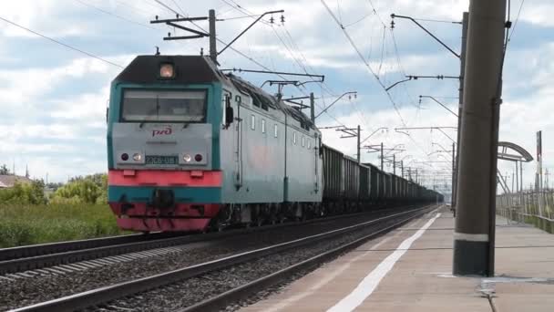 Cargo train passing station in the countryside — Stock Video